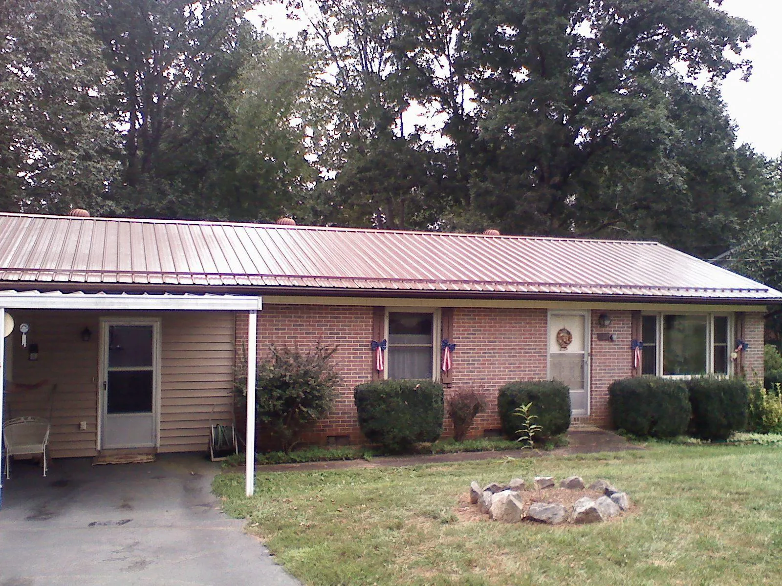 Bronze metal roof and carport on a brick ranch home — Roof Repair work by our crew in Coral